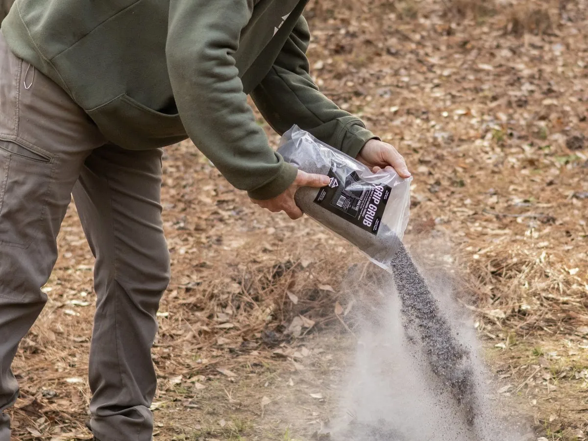 Pouring Grip Grub deer mineral onto a fresh mineral site