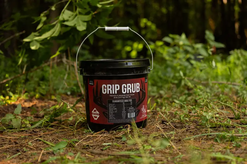 Grip Grub deer mineral — 20 lb bucket at a woodland mineral site