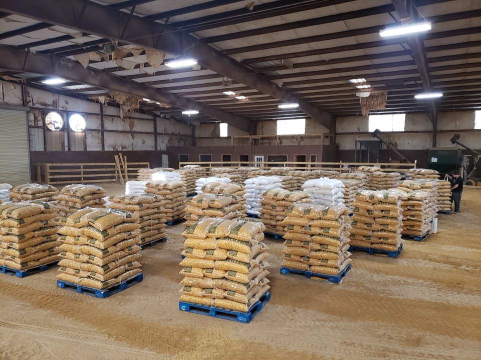 Pallets of feed staged on the dirt floor of the horse barn.
