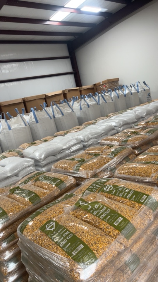 Pallets of Triple Grip bags and peanut totes stacked in the warehouse.