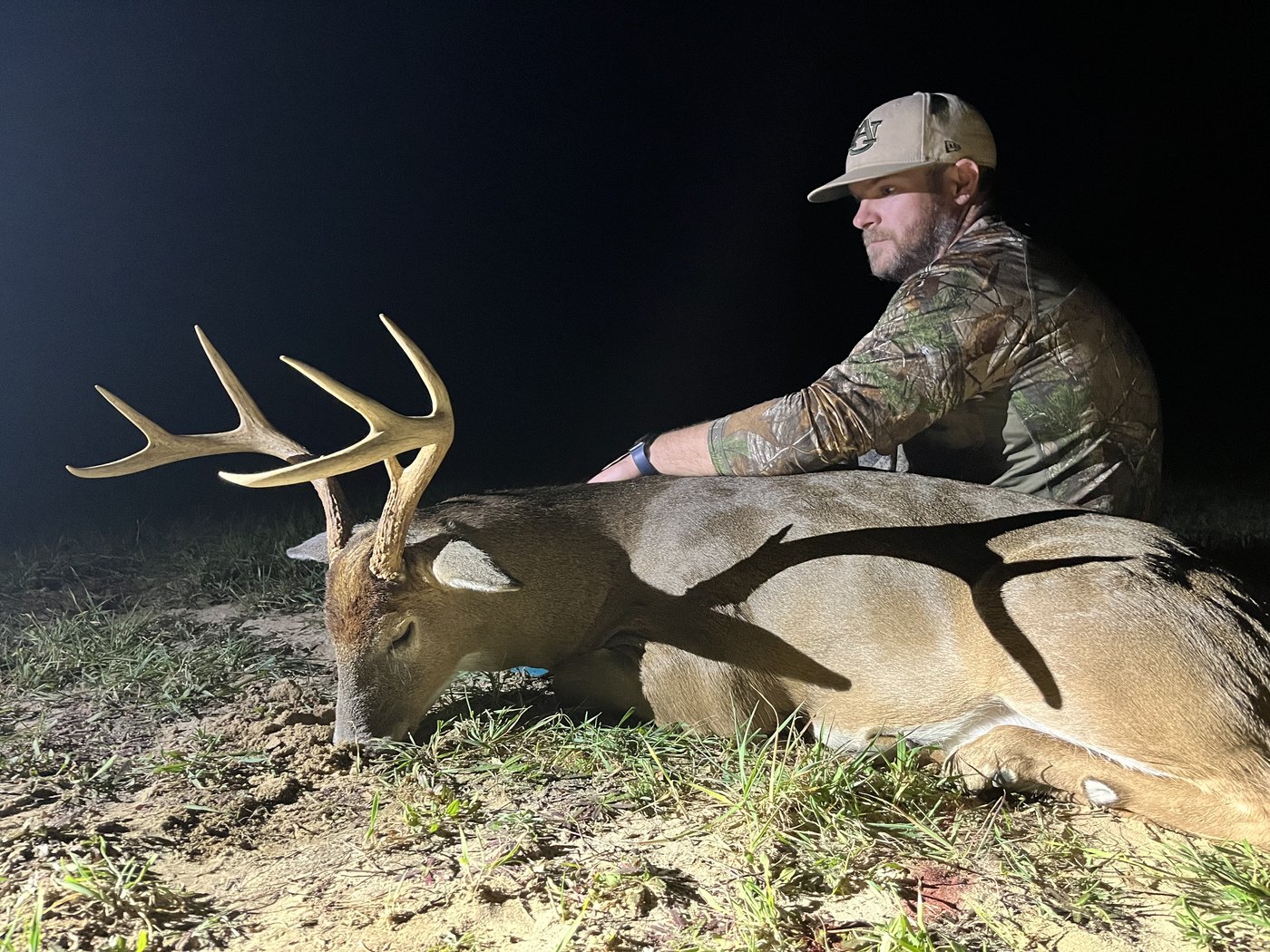 Hunter with a mature buck taken after dark