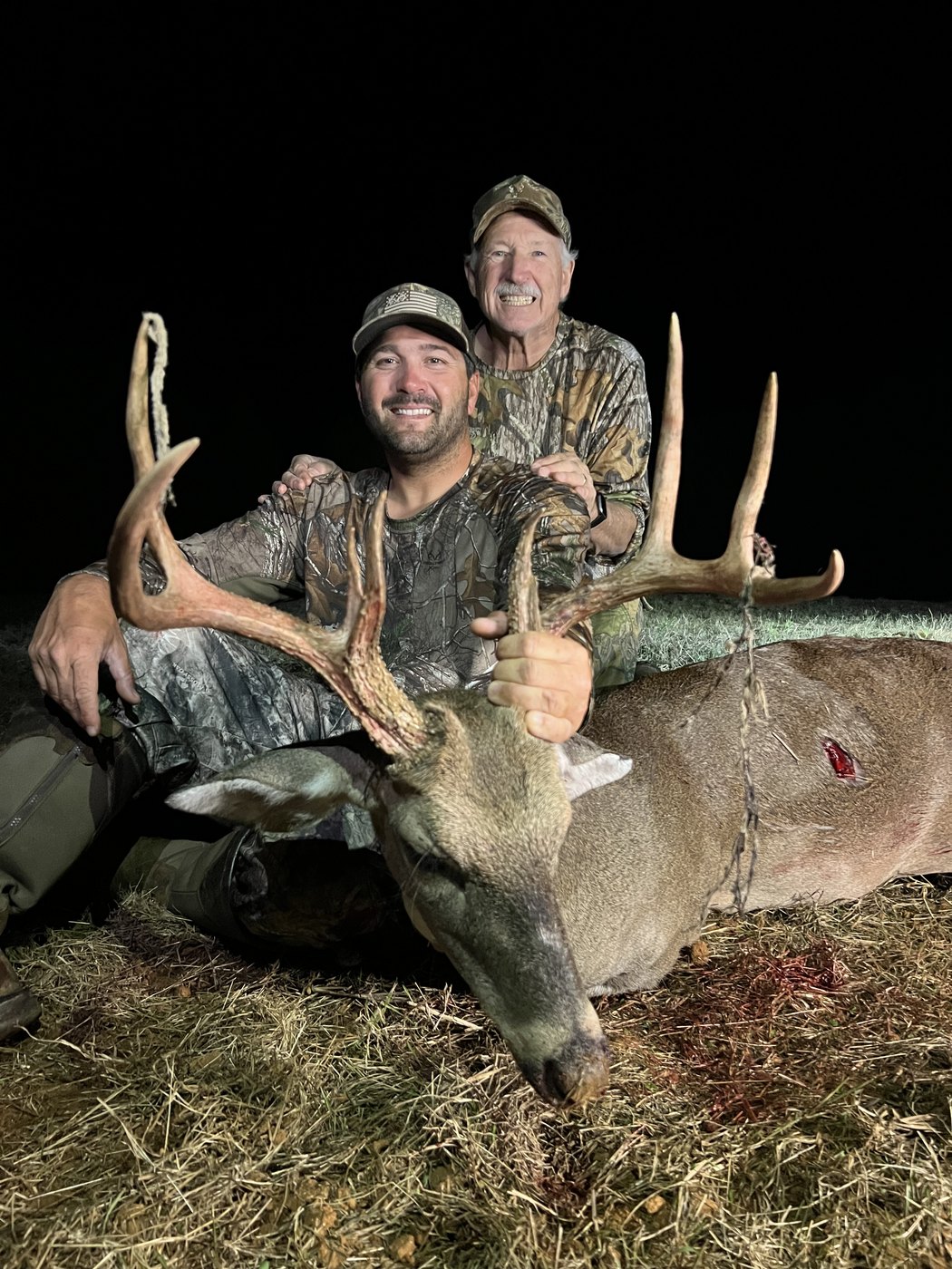 Hunter with a heavy-beamed buck at night