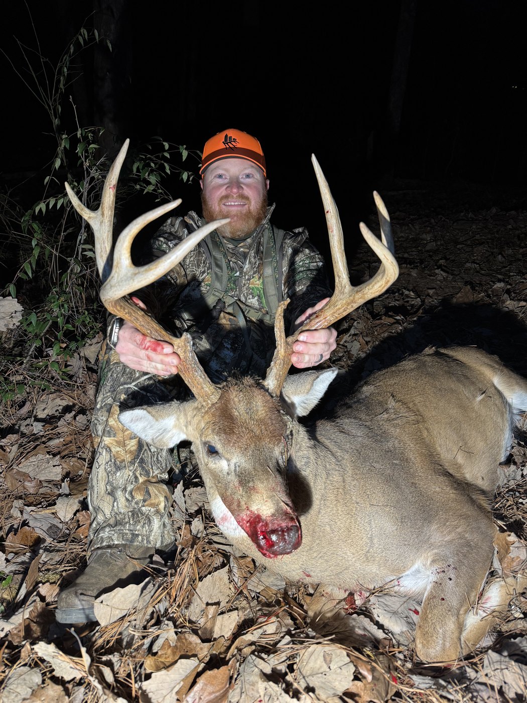 Hunter in blaze orange with a heavy whitetail buck