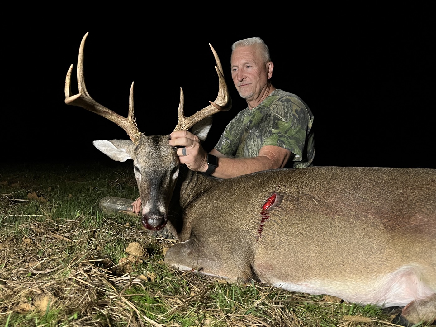 Hunter with a heavy-beamed whitetail buck taken after dark