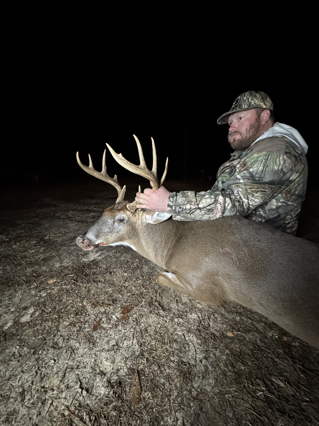 Hunter behind a mature buck at night