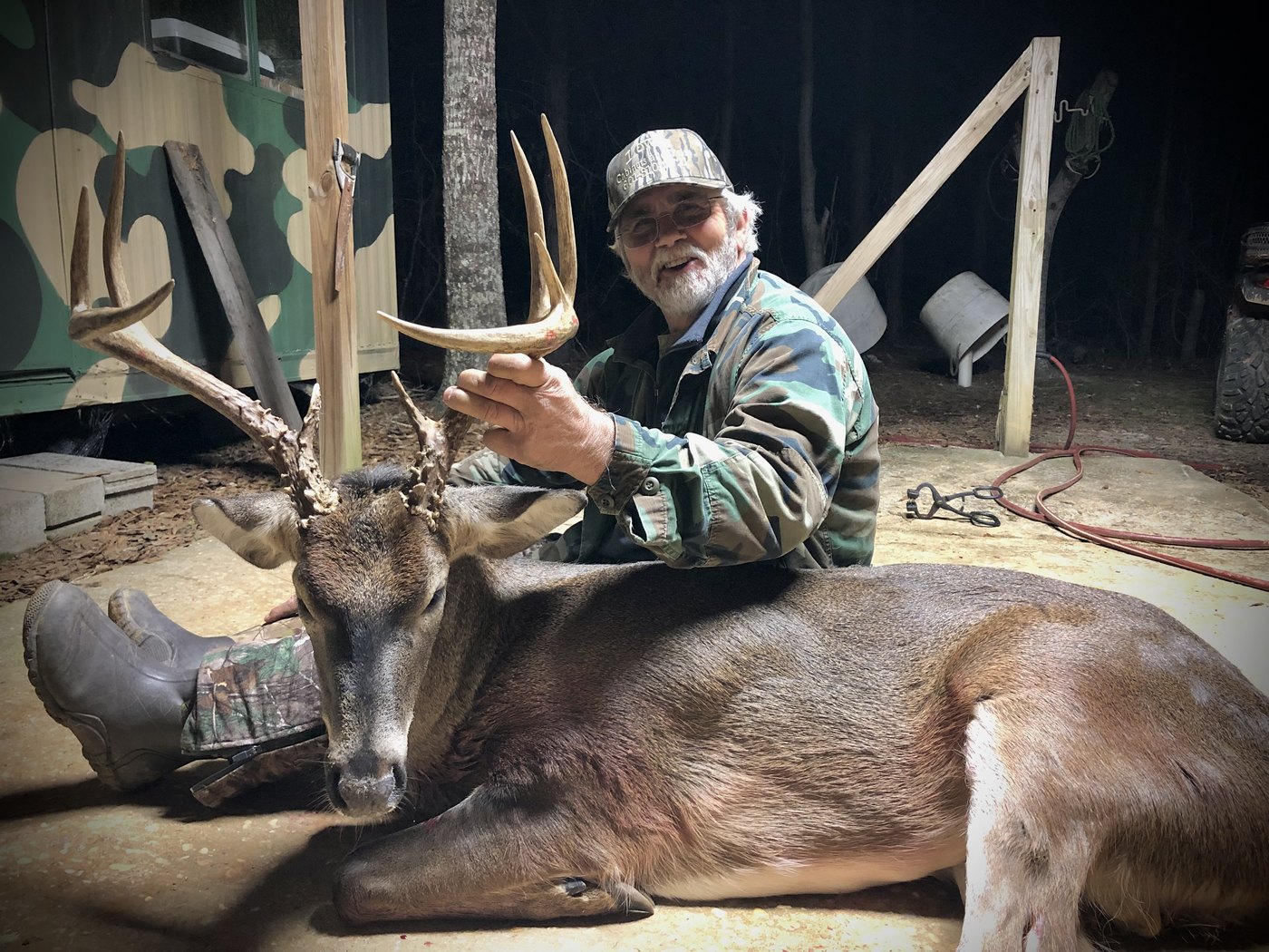 Hunter with a mature whitetail buck in a shed