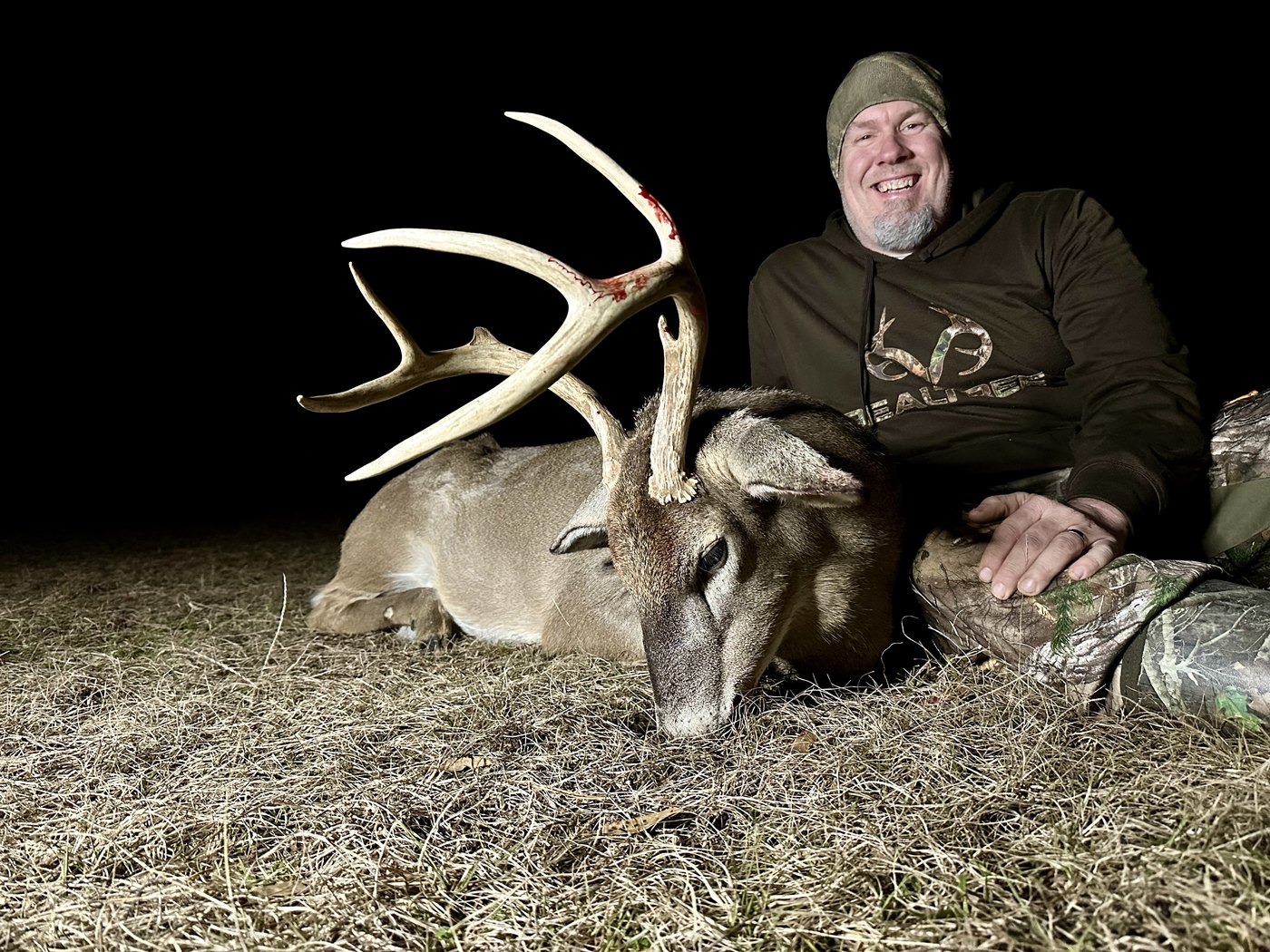 Hunter with a heavy-beamed buck taken after dark