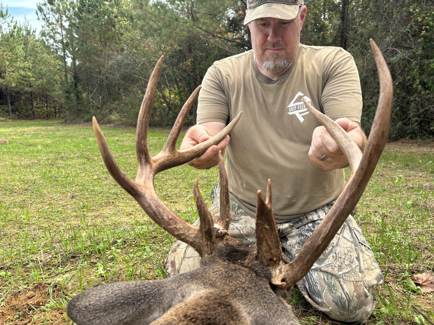 Hunter in a Grip Feed shirt holding up a heavy typical rack